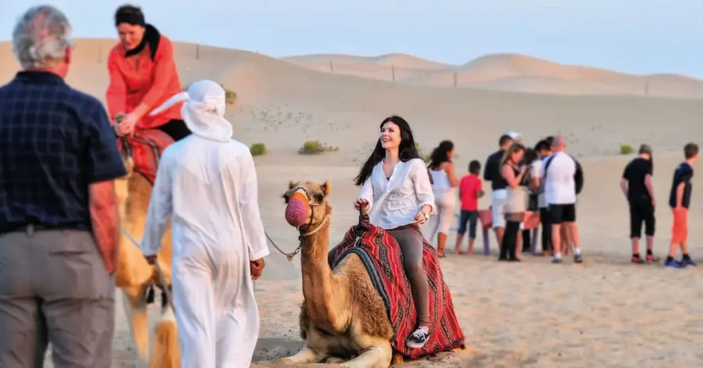 a girl riding camel in a desert side of abu dhabi